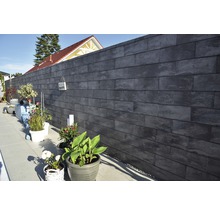 Gartenmauer aus Betonsteinen mit Pflanzen in Töpfen