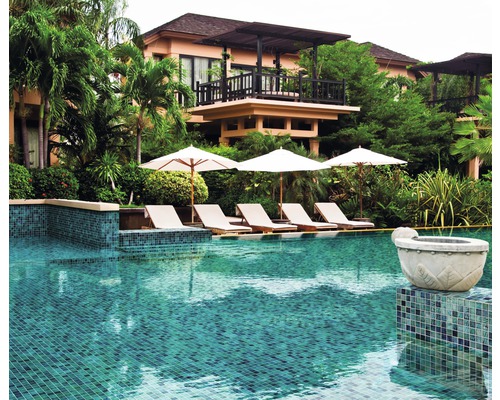 Swimmingpool mit Liegestühlen und Sonnenschirmen vor einem Gebäude