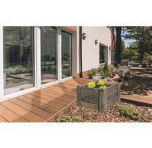 Außenbereich mit quadratischem Pflanzkasten in Holzoptik neben einer Terrasse