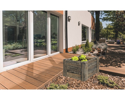 Außenbereich mit quadratischem Pflanzkasten in Holzoptik neben einer Terrasse