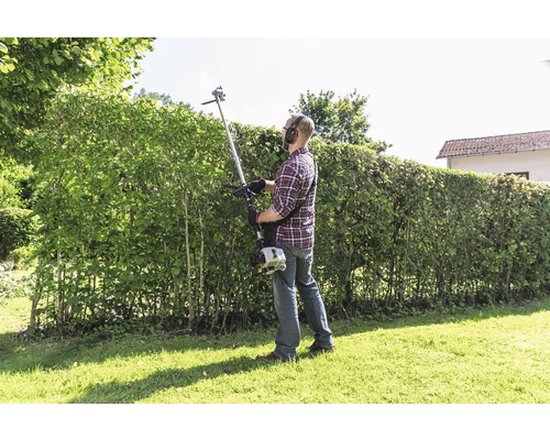 Mann schneidet Hecke mit einer Heckenschere.