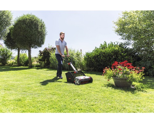 Mann benutzt Rasenlüfter im Garten.