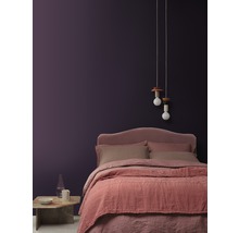 Schlafzimmer mit Bett, Nachttisch, Lampe und dekorativer Wandgestaltung für eine gemütliche Atmosphäre.