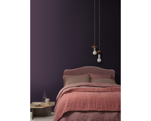 Schlafzimmer mit Bett, Nachttisch, Lampe und dekorativer Wandgestaltung für eine gemütliche Atmosphäre.
