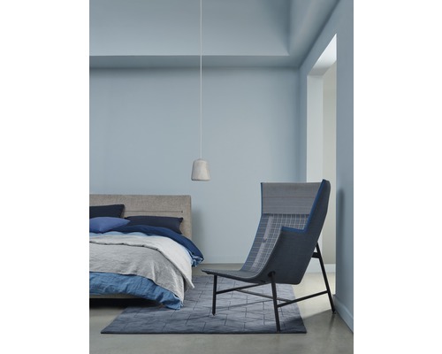 Schlafzimmer mit Bett, Hängelampe, Teppich und Sessel