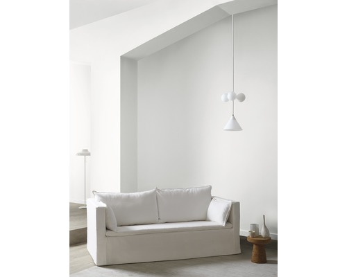 Helles Wohnzimmer mit einem weißen Sofa, einer Hängelampe und einem Beistelltisch