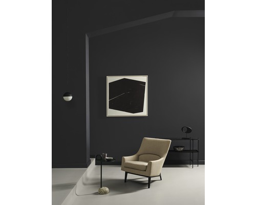 Wohnzimmer mit Sessel, Beistelltisch und Wandbild in einem modernen, hellen Design