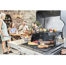 Szene im Freien mit Menschen, die um einen Holztisch sitzen und ein Barbecue mit einem Char-Broil Grill zubereiten.