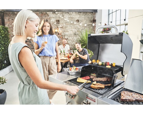 Szene mit Personen, die an einem Grill mit Grillgut stehen