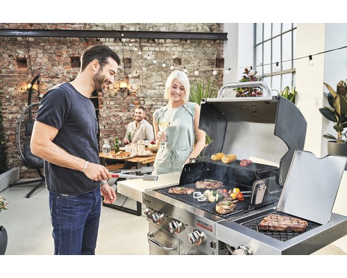 Szene mit Menschen beim Grillen im Freien mit einem Holzkohlegrill