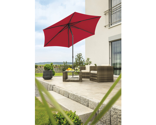 Terrasse mit rotem Sonnenschirm und Gartenmöbeln aus Rattan.