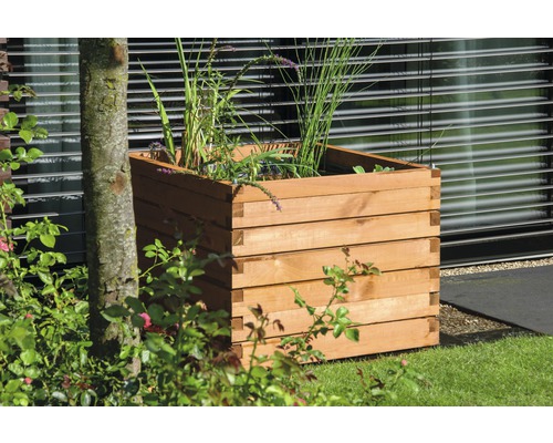 Quadratischer Pflanzkasten aus Holz im Garten.