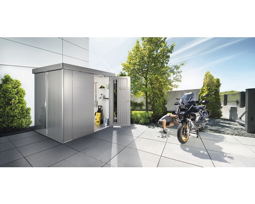 Metall Gerätehaus mit geöffneter Tür, Motorrad und Person im Garten.