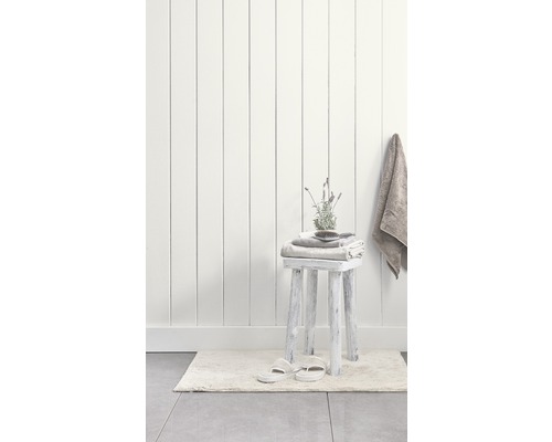 Badezimmer mit Hocker, Handtüchern, Badematte und Hausschuhen vor einer Wand mit Holzpaneelen