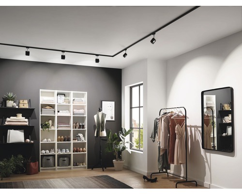 Modernes Ankleidezimmer mit schwarzer Schienenbeleuchtung, Regalen und Kleiderständer