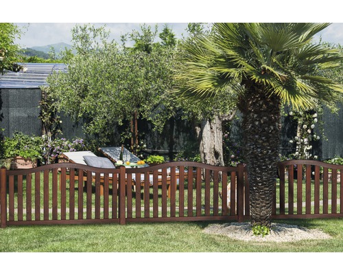 Gartenszene mit Holzzaun, Liegestuhl und Bäumen