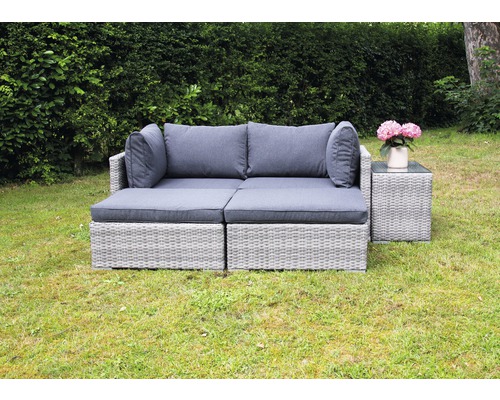 Gartenszene mit grauem Lounge-Set aus Polyrattan und Beistelltisch mit Glasplatte