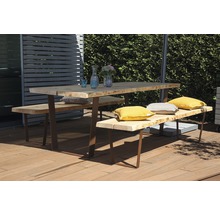 Gartentisch mit Bänken und Kissen auf einer Holzterrasse