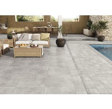 Terrasse mit grauen Bodenfliesen, Gartenmöbeln und Swimmingpool