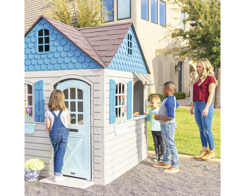 Spielhaus mit Kindern und Erwachsenen im Garten.