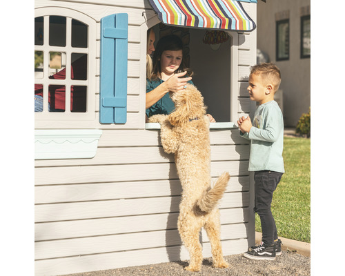 Kinderspielhaus mit Kindern und Hund im Garten