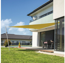 Dreieckiges Sonnensegel auf einer Terrasse mit Garten und Wohnhaus