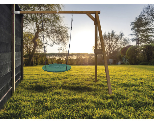 Grüne Tellerschaukel am Holzgerüst im Garten