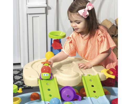 Ein kleines Mädchen spielt mit einem Wasserspieltisch für den Außenbereich.