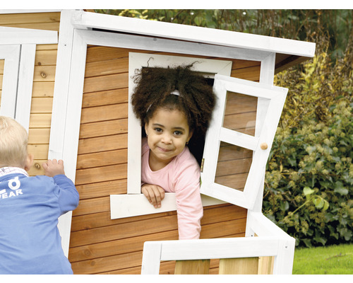 Kind im Fenster eines Spielhauses aus Holz