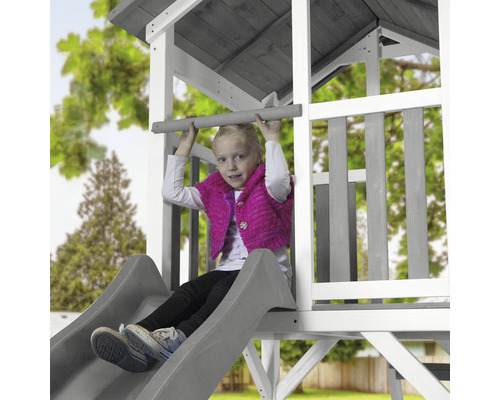 Mädchen auf Spielturm mit Rutsche und Kletterstange