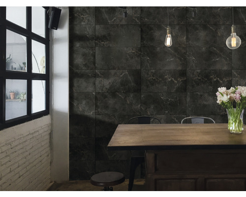 Innenraum mit dunklen Marmorfliesen an der Wand, Esstisch und Stühlen.