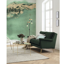 Helles Wohnzimmer mit grüner Couch, Couchtisch und gemusterter Tapete