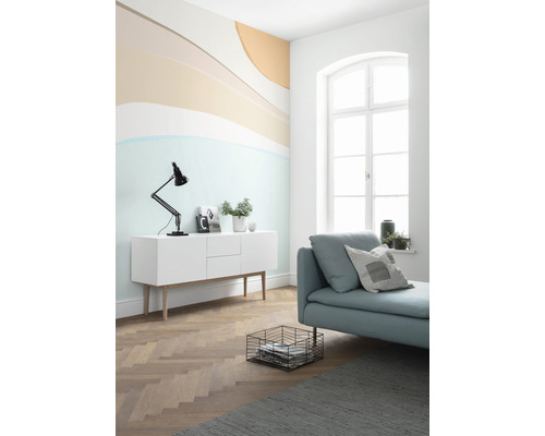 Heller Wohnraum mit Kommode, Tagesbett und abstrakter Wandgestaltung für ein freundliches Ambiente.