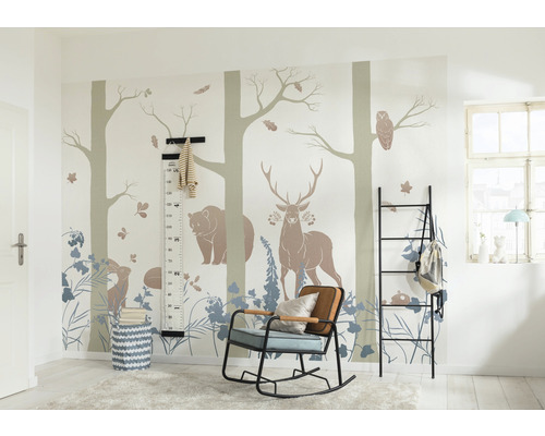 Kinderzimmer mit Waldtiermotiven auf der Wand, einem schwarzen Regal, einem Schaukelstuhl und einer Messlatte.
