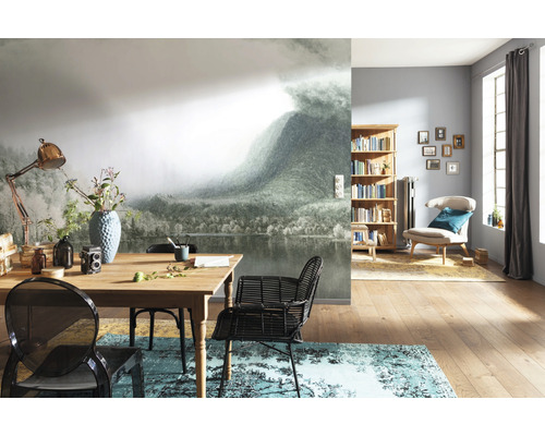 Wohnzimmer mit Fototapete Berglandschaft, Holztisch, Stühlen und Bücherregal