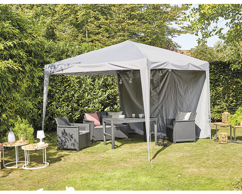 Grauer Pavillon mit Gartenmöbeln auf einer Rasenfläche