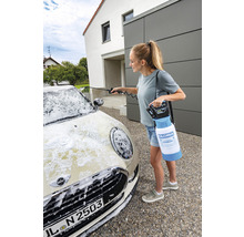 Eine Frau reinigt ein Auto mit einem Akku-Schaumsprüher von Gloria.