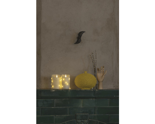 Dekorative Szene mit LED Kerzen, einer gelben Vase, einem Holzhandmodell und einer Wanddekoration auf einem Regal.