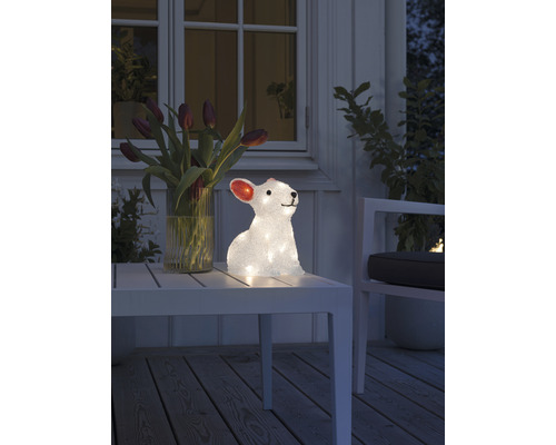 Dekorativer Hase mit Beleuchtung auf einem Tisch im Außenbereich.