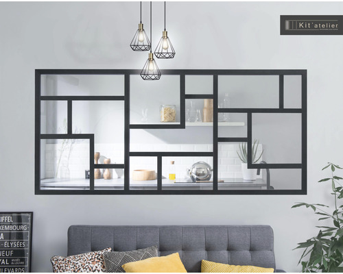 Wohnzimmer mit grauem Sofa, dekorativen Kissen, Zimmerpflanze, Design Lampe und Wandregal mit Spiegel