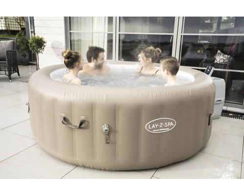 Aufblasbarer Lay-Z-Spa Whirlpool mit vier Personen im Wasser auf einer Terrasse