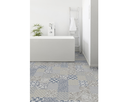 Badezimmer mit Badewanne, Leiter und Bodenfliesen im Patchworkdesign