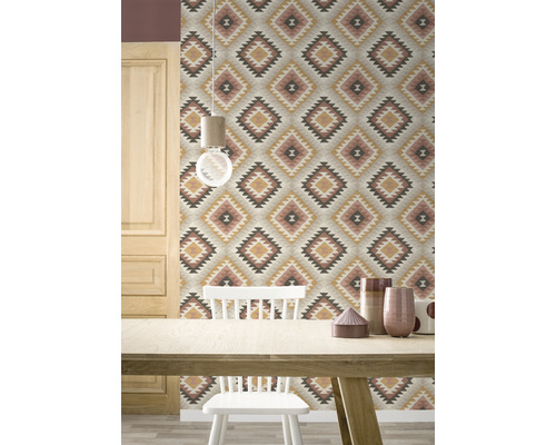 Raumansicht mit gemusterter Tapete, Holztisch und Stuhl