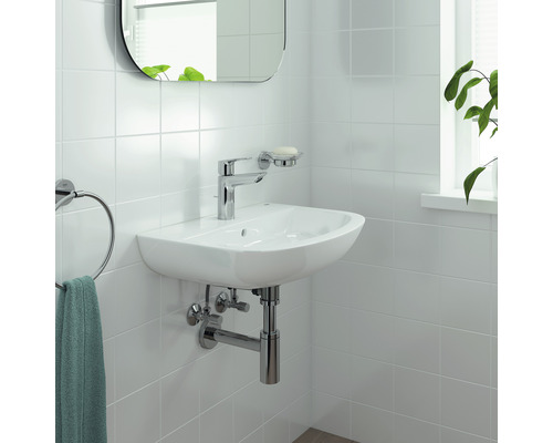 Helles Badezimmer mit Waschbecken, Armatur, Handtuchhalter und Spiegel