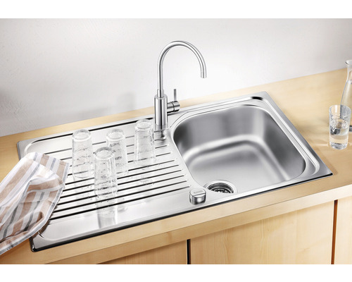 Edelstahlspüle mit Abtropffläche, Wasserhahn und Gläsern