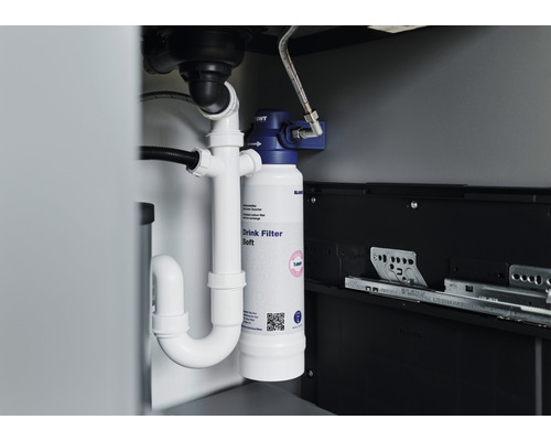 Installierter Wasserfilter unter einer Spüle mit Rohren.