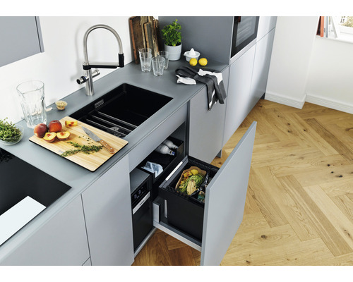 Moderne Küche mit Spüle, Armatur, Schneidebrett mit Pfirsichen und offenem Müllauszugssystem