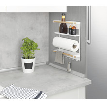 Küchenszene mit magnetischem Küchenrollenhalter mit Gewürzen, Küchenrolle, Geschirrtuch und Reibe an einer Kühlschranktür
