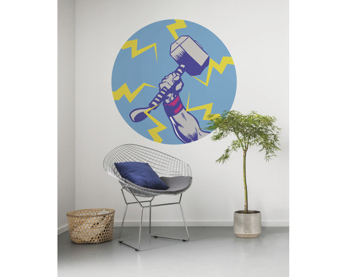 Dekoratives Wandbild mit Hammer-Motiv in einem Zimmer mit Stuhl und Pflanze.