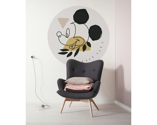 Wohnszene mit Sessel und abstrakter Mickey Maus Wanddekoration.